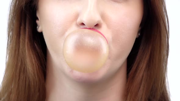 Girl Blowing a Big Bubble Gum Bubble. White Background. Slow Motion alt