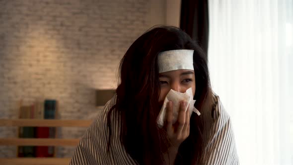 Young Asian Woman Suffering From Cold and Illness and Lying in Bed with Tissue at Home alt