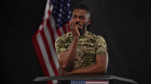 Portrait of Serious Male African American Soldier Clarifying Question From Audience Standing at alt