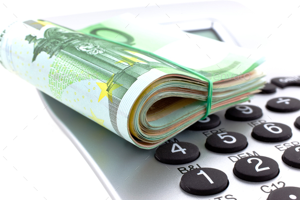 rolled with rubber euro notes with calculator - Stock Photo - Images