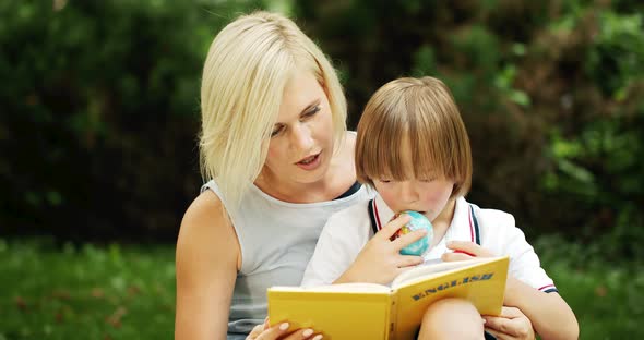 Down Syndrome Boy With Mother Reading Book