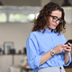 Young business woman holding mobile phone standing in office using cell. - PhotoDune Item for Sale