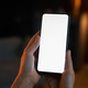 Vertical closeup female hand holding phone with white screen mockup in dark - PhotoDune Item for Sale