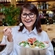Middle-aged happy woman eating salad in restaurant, joyful face close-up - PhotoDune Item for Sale