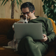 thirty-year-old man with laptop and dog sitting at home on the couch - PhotoDune Item for Sale