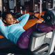Black athletic woman practicing sit-ups while working out in a gym. - PhotoDune Item for Sale