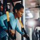 African American athletic woman using suspension straps while working out in gym. - PhotoDune Item for Sale