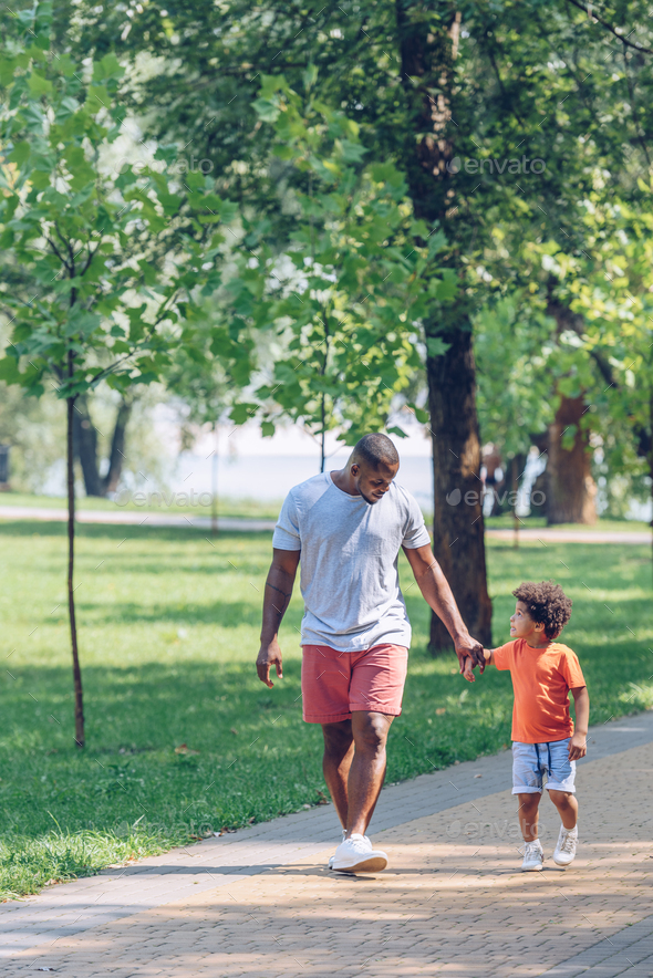 African American Father And Son Holding Hands And Looking At Each Other