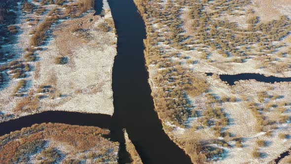 Aerial View Of Forest Woods And Partly Frozen River Landscape In Sunny Late Autunn Day alt