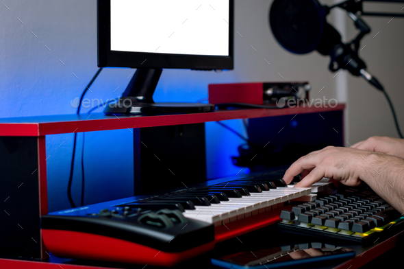 young caucasian male hands playing electric piano in home music studio