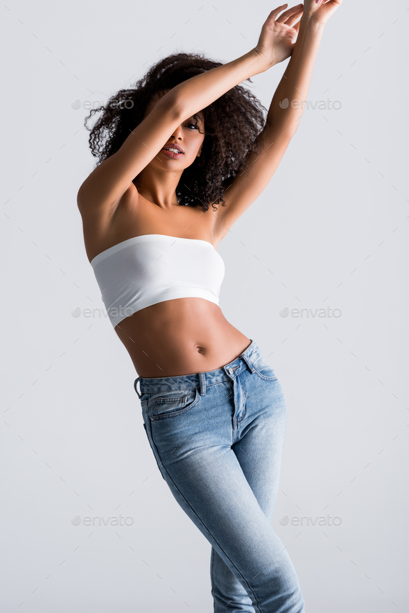 african american woman in white top obscuring face isolated on grey
