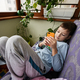 Boy plays phone on the sofa at balcony. - PhotoDune Item for Sale