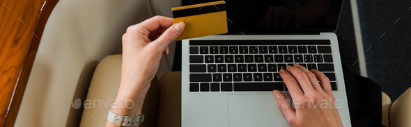 panoramic shot of businesswoman with credit card near laptop in private jet - Stock Photo - Images