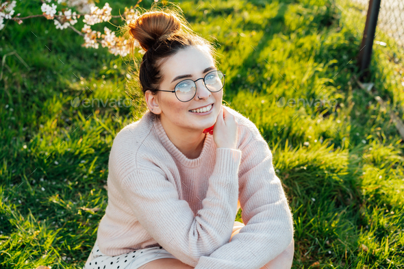 Portrait of young smiling caucasian hipster girl in glasses with pimples, acne on her face.