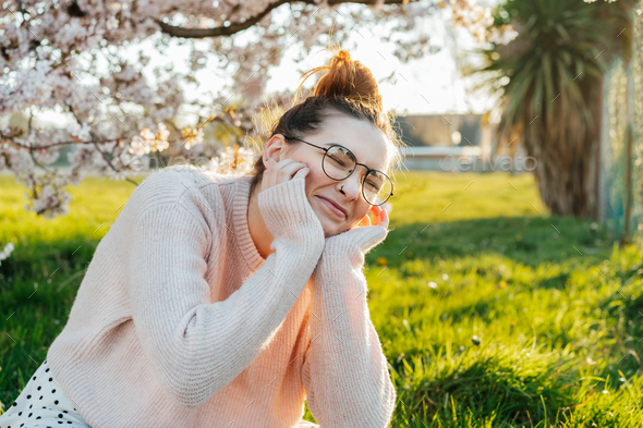 Portrait of young laughing caucasian hipster girl in glasses with pimples, acne on her face.