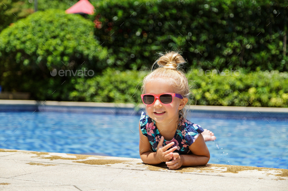 Happy little caucasian toddler girl with sunglasses smiling joyfully and enjoying summer vacations - Stock Photo - Images