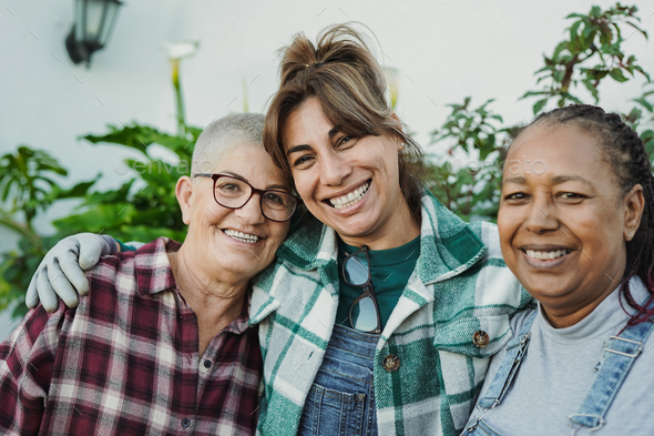 Mature multiracial women having fun gardening together at home patio - Elderly female friends