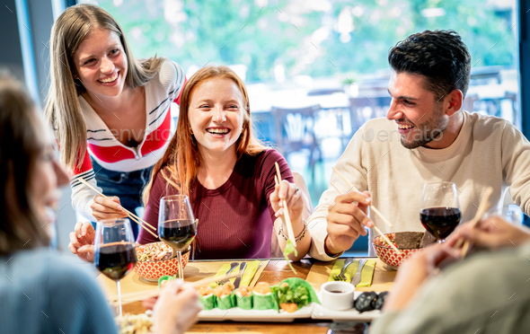 Young trendy friends eating with chopsticks at sushi bar restaurant - Stock Photo - Images