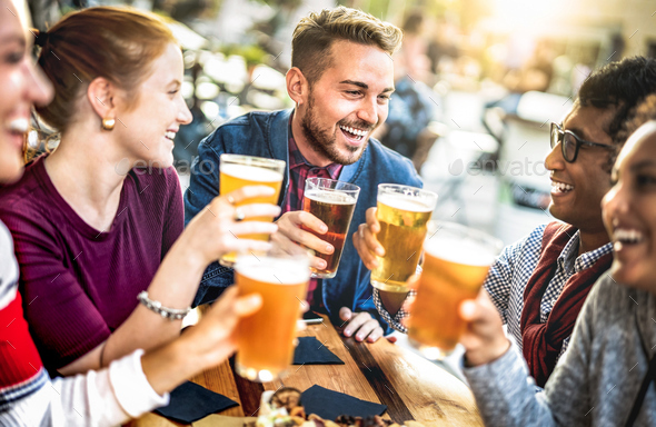 Young people drinking beer pints at brewery bar garden - Stock Photo - Images