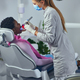 Woman performing a dental procedure on a patient - PhotoDune Item for Sale