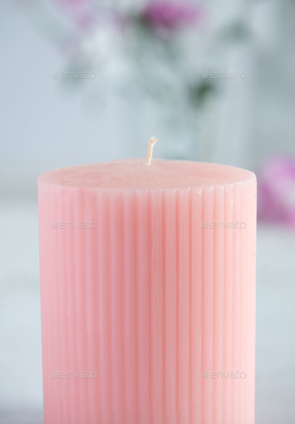 unlit pink candle on floral background - Stock Photo - Images