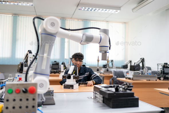 Engineer check and control automation robot arms machine in factory. robotics manufacturing.