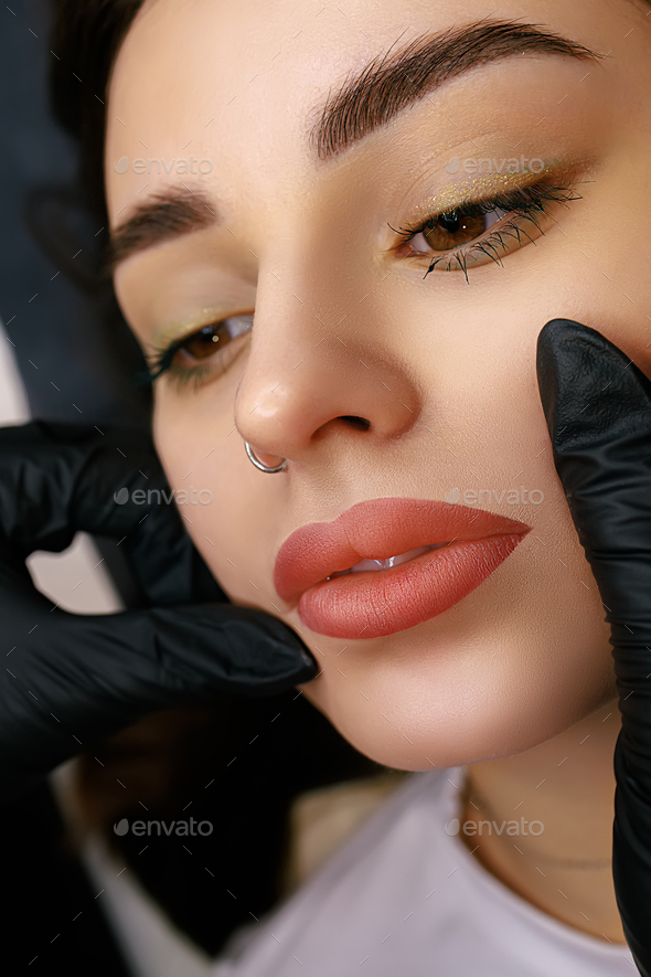 Beautiful lips of a girl with a permanent make-up of the lips close-up. Lip tattoo matte effect.