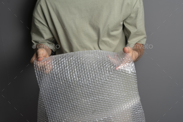 a person holding and bursting bubble protective wrap trying to calm down