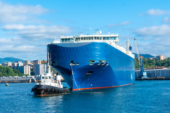 Cargo ship transporting a giant ship in the bay of Pasaia to the open sea Pasajes, Gipuzkoa, Spain