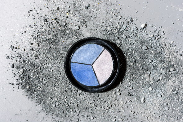 Box with blue eye shadows on crushed grey powder