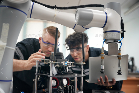 Robotics control engineers setting programming of control panel for ...