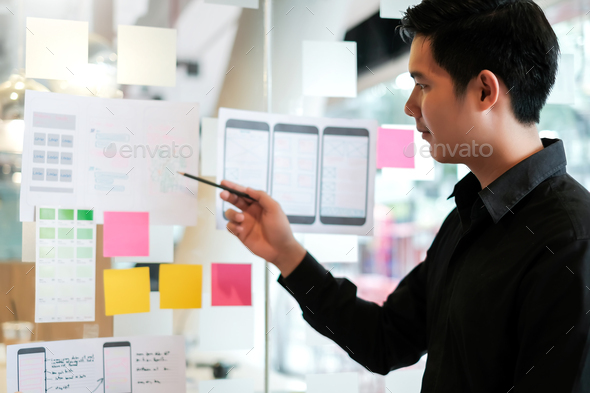 Male designer creative idea website designer Draw outline and develop applications on smartphone.