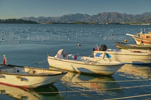 Fishing boats on the pier against the backdrop of the bay Stock Photo by  edchechine