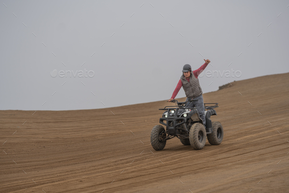 Man gesturing to be okay while driving a quad bike