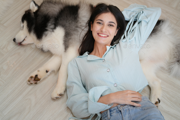 Woman laying on floor with a dog