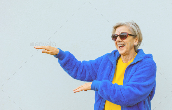 happy elder woman wearing sunglasses and modern stylish jacket