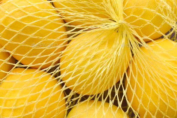 Lemon in a mesh bag. Stock Photo by Maliflower73