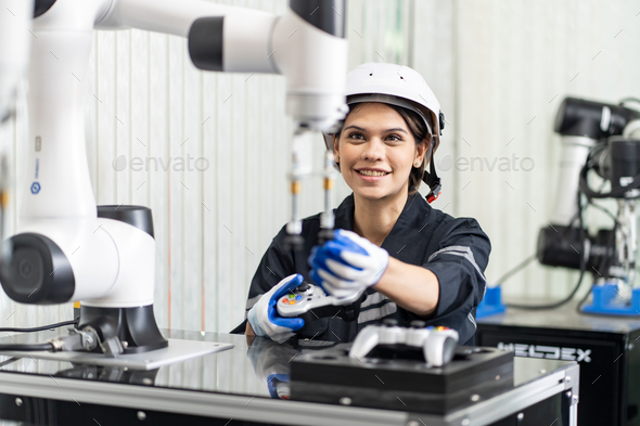 Female Engineer check and control automation robot arms machine in factory. robotics manufacturing.