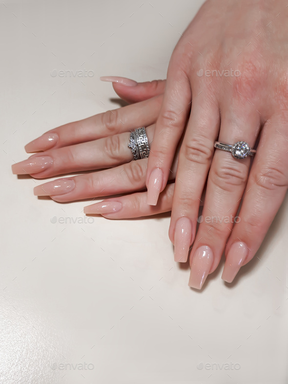 Acrylic nail extension, manicure, nail correction, hands in the foreground. Reflective design.