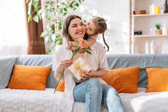 Daughter hugged her mother and gave a gift and flowers, mother's day ...