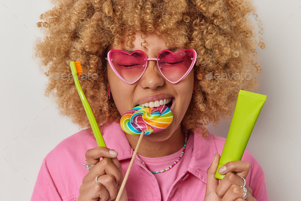 Young Woman with Lollipop in Her Mouth Wearing Sunglasses