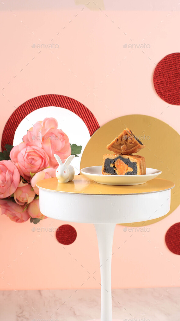 Mooncake on Light Pink Background with Pink Flower. Concept Moon Cake on Mid Autumn Festival.