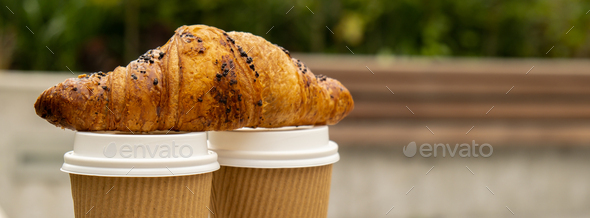 Fresh baked chocolate croissant on Two paper cups with lid for tea to go. Breakfast Coffee take away