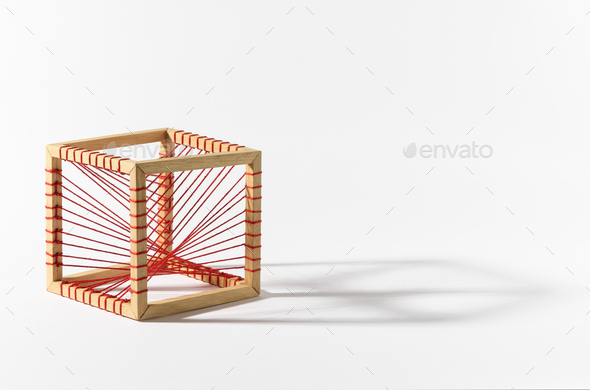 Wooden cube with red threads