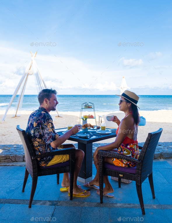 Luxury breakfast on the beach of Phuket Thailand, couple having breakfast outdoor on the beach
