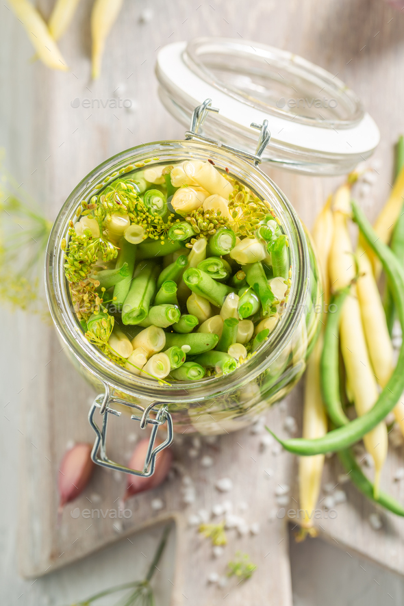 Healthy pickled yellow and green beans with galic and dill. Stock Photo by Shaiith