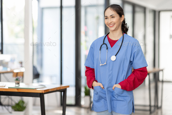 portrait of Cheerful Indian beautiful Asian female doctor posing and smiling at camera, healthcare