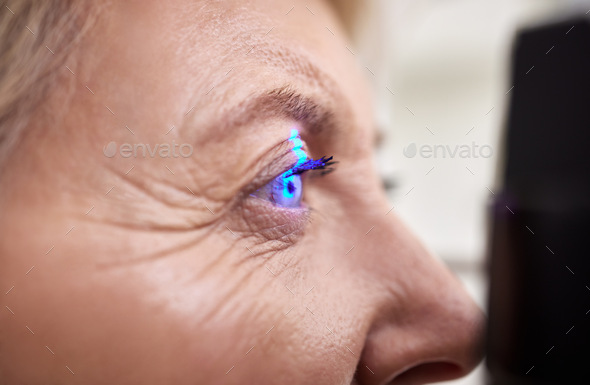 Eye exam, vision or laser test for an old woman with a machine at optometry consultation for retina - Stock Photo - Images