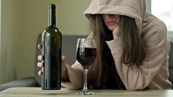 Unkempt Woman Drinking Wine Alone alt