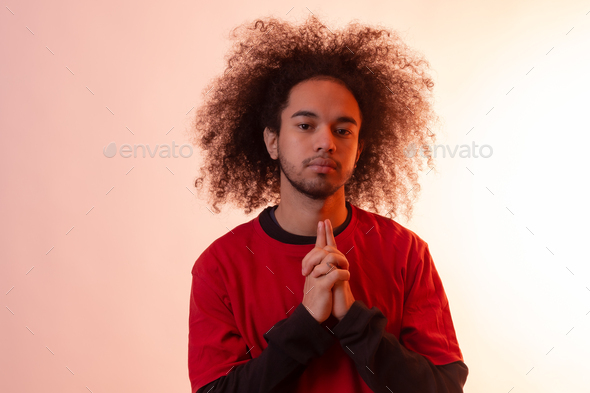 Portrait with a red led light. Young man with afro hair on white background